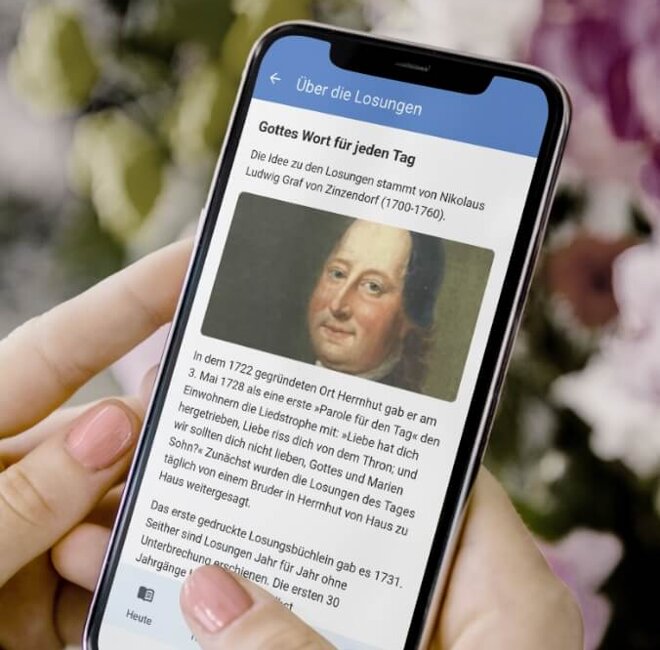 Smartphone mit der geöffneten Losungen App. In der Überschrift ist Gottes Wort für jeden Tag zu lesen darunter ist ein Gemälde von Ludwig Graf zu sehen.
