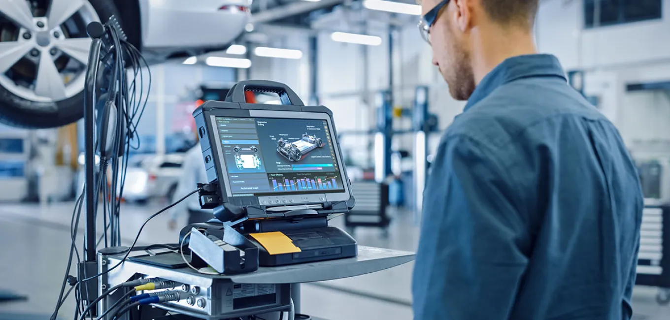 Robustes Industrie-Tablet mit grafischer Bedienoberfläche zur Fahrzeugdiagnose, bedient von einem Techniker