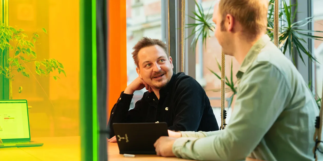 Zwei Männer sitzen an einem Tisch und unterhalten sich